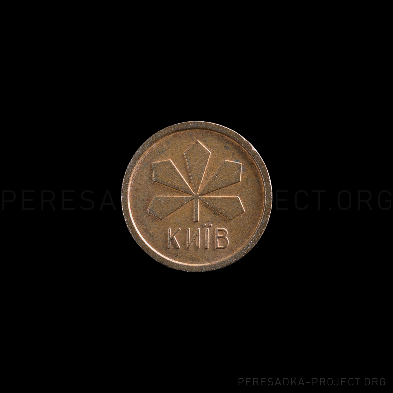 Фото жетона Киев 1992. Реверс на чёрном фоне. Порошковый металл диаметром 21.3 мм, Киев, Украина. Жетон из проекта «Пересадка» – частного каталога-музея по теме метро.