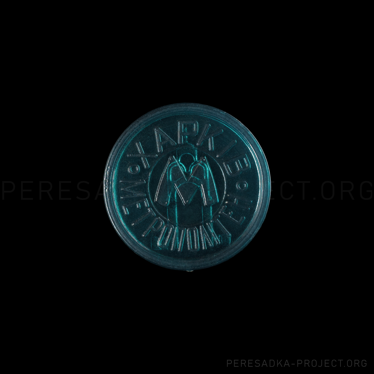 Фото жетона Харьков Зеркальная струя. Жетон на чёрном фоне. Прозрачный пластик диаметром 25 мм, Харьков, Украина. Жетон из проекта «Пересадка» – частного каталога-музея по теме метро.