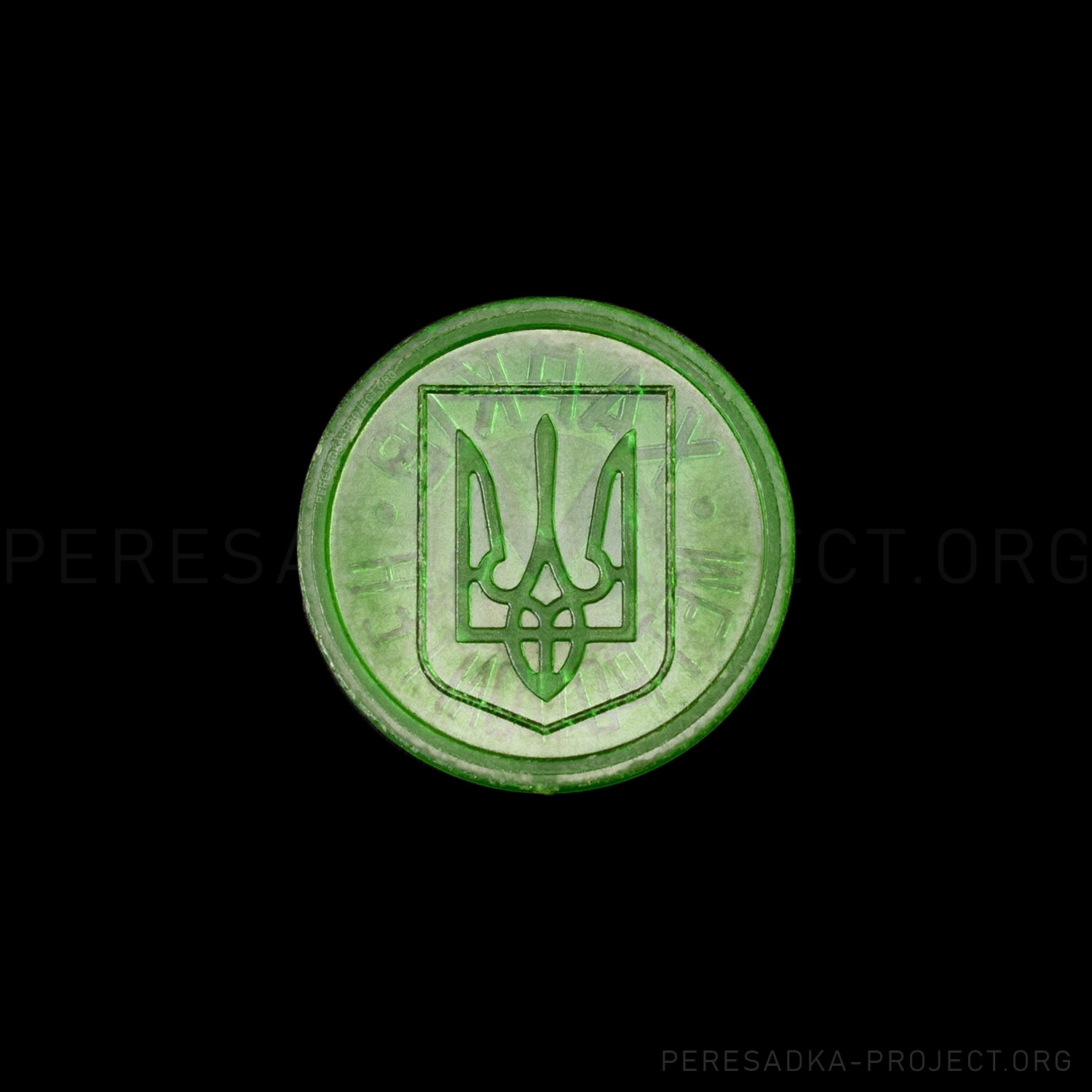 Фото жетона Харьков герб прозрачный зелёный. Реверс на чёрном фоне. Прозрачный пластик диаметром 25 мм, Харьков, Украина. Жетон из проекта «Пересадка» – частного каталога-музея по теме метро.
