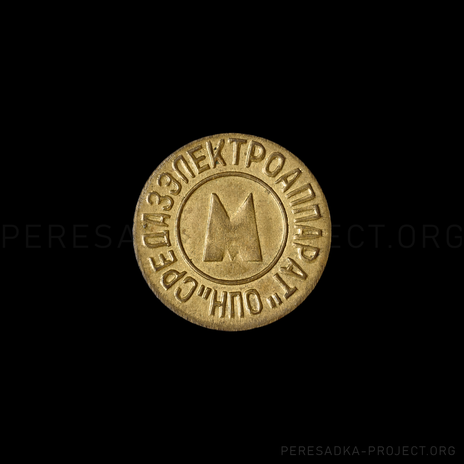 Фото жетона Ташкент латунь. Реверс на чёрном фоне. Латунь диаметром 24 мм, Ташкент, Узбекистан. Жетон из проекта «Пересадка» – частного каталога-музея по теме метро.