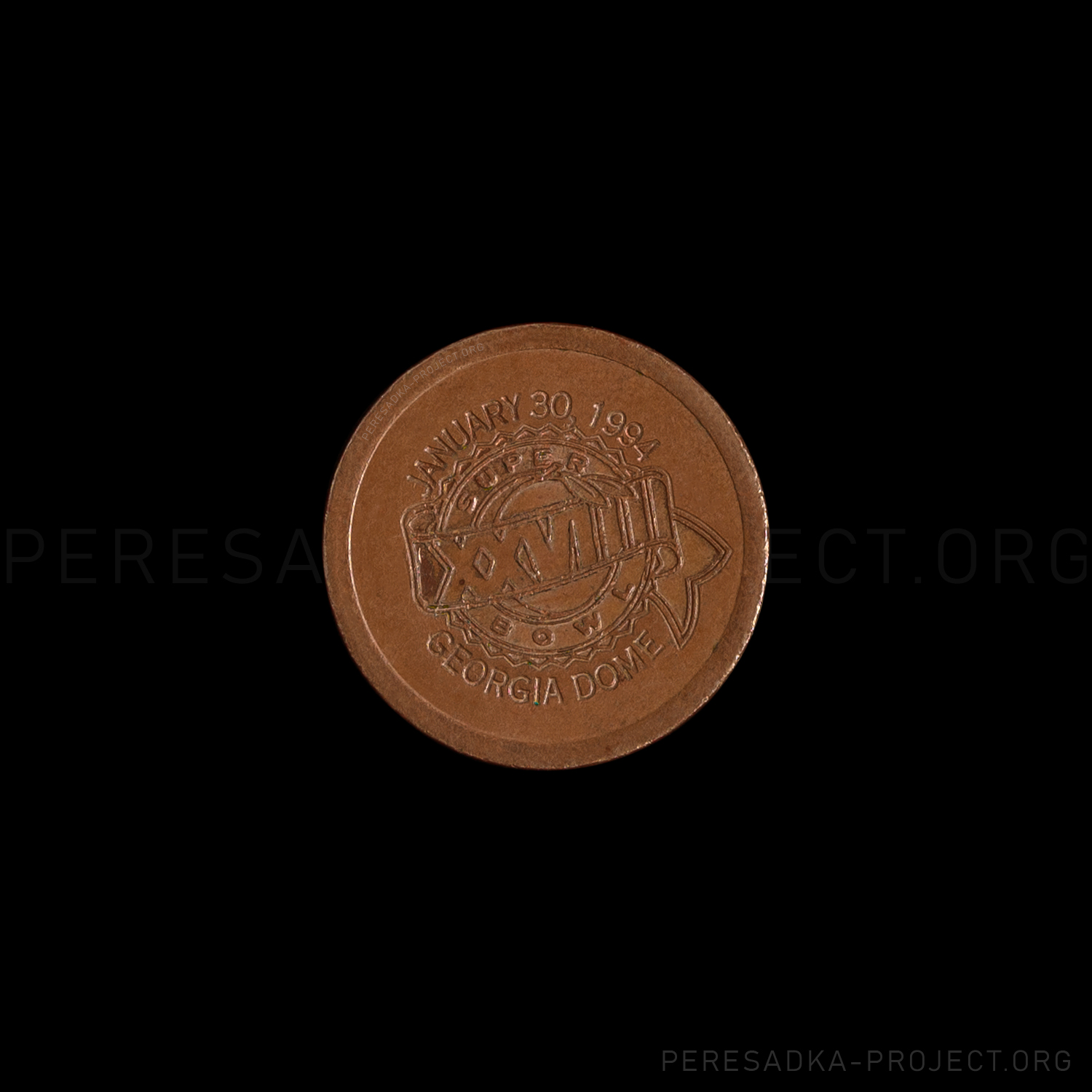 Фото жетона Атланта Super Bowl XXVIII. Реверс на чёрном фоне. Медь диаметром 23 мм, Атланта, США. Жетон из проекта «Пересадка» – частного каталога-музея по теме метро.